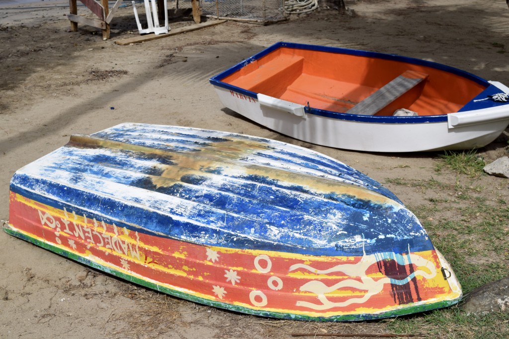 walk along the beach with brightly colored boats