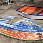 walk along the beach with brightly colored boats